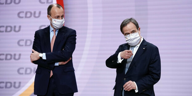 Friedrich Merz und Armin Laschet mit Maske auf einer Bühne