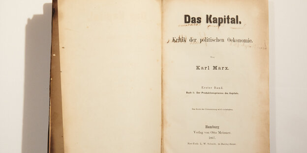 Ein altes, aufgeschlagenes Buch mit dem Titel "Das Kapital"