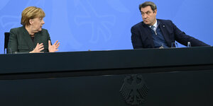 Merkel und Söder schauen sich bei einer Pressekonferenz an