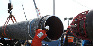 Arbeiter schauen in die Röhren einer Erdgas Pipeline