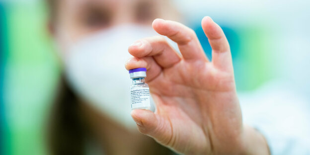 Eine medizinische Mitarbeiterin hält eine Impfstoffdose mit Corona-Impfstoff in der Hand