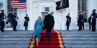 Joe Biden und seine Frau laufen über einen roten Teppich die Stufen hinauf zum Weißen Haus