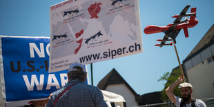 Zwei Demonstranten mit Schildern und Modell-Drohne