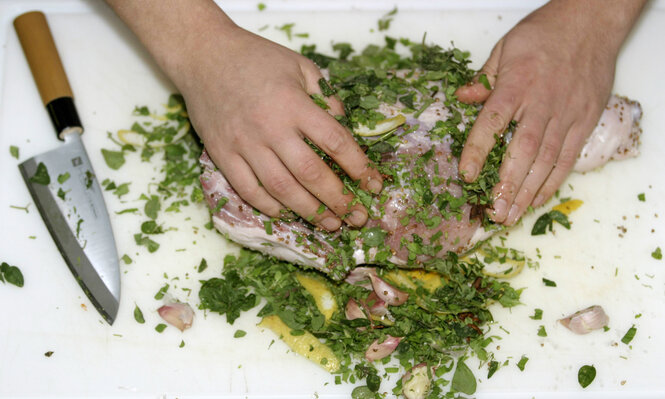 Ein paar Hände, das Marinade in Fleisch massiert