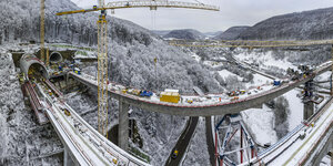 Bauarbeiten an einer ICE-Strecke über eine Brücke in verschneiter Landschaft