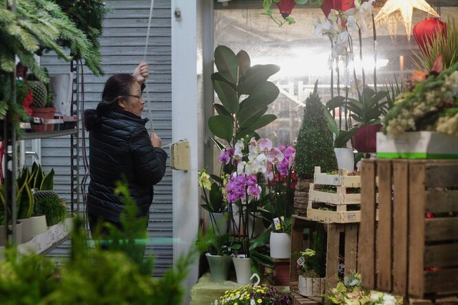 Die Mutter der Autorin schließt den Rolladen des Blumenladens