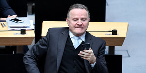 Der AfD-Fraktionschef Georg Pazderski schaut im Abgeordnetenhaus auf sein Handy