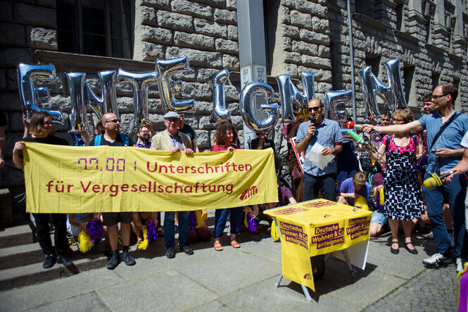 Menschen stehen um einen Tisch