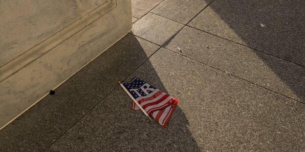 Ein USA-Flagge liegt geknickt auf dem Boden