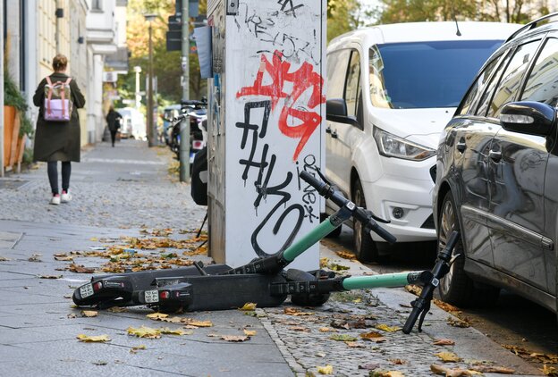 E-Roller zum Ausleihen liegen umgestürzt am Rand eines Gehwegs in Berlin E-Roller zum Ausleihen liegen umgestürzt am Rand eines Gehwegs in Berlin