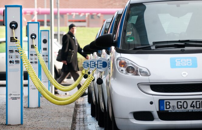 Weiß-blaue Ladensäulen für E-Autos laden weiß-blaue E-Autos eines Carsharinganbieters