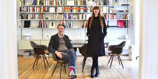 Wenzel Taraba, sitzend, und Tanja Kriebel, stehend, vor ihrem Bücherregal