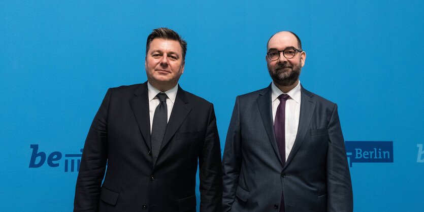 Andreas Geisel, Innensenator, und Michael Fischer, bei einer Pressekonferenz. Sie tragen beide dunkle Anzüge.