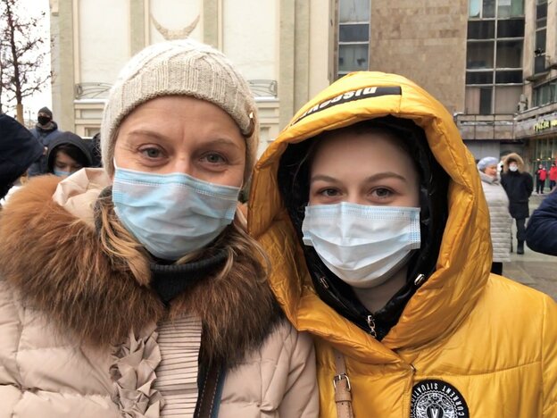 Zwei Frauen mit Mundschutz stehen dicht nebeneinander