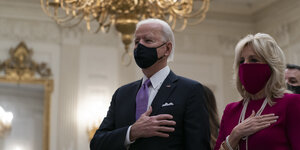 Joe Biden (l), Präsident der USA, und seine Frau Jill Biden legen während einer online Gebetsveranstaltung im Zuge seiner Amtseinführung im State Dinning Room des Weißen Hauses ihre Hand aufs Herz.