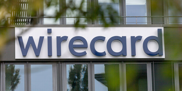 Das Logo der insolventen Firma Wirecard hängt an der Fassade des Unternehmens in Aschheim bei München.