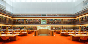 Oranger Teppich, Bücherregale, Arbeitsplätze und oben eine Glasdecke im neuen Stabi-Lesesaal Unter den Linden