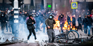 Regierungskritische Demonstranten geraten bei einer Kundgebung am Museumsplatz in Amsterdam mit Polizisten aneinerander - wütende Demonstranten - Politisten mit Schlagstöcken auf Pferden