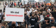 "Wir sind systemrelevant!" steht auf einem Plakat, das einer von hundert Menschen auf einer Demonstration der Veranstaltungsbranche zeigt.