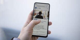 Jemand hät ein Smartphone mit geöffneter Browseransicht von tagesschau.de