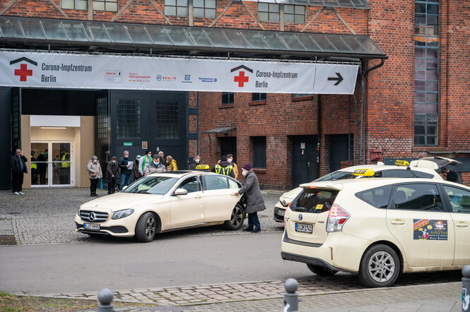 Vor dem Eingang des Impfzentrums in der Treptow Arena stehen mehrere Taxis, die auf Kundschaft wartet