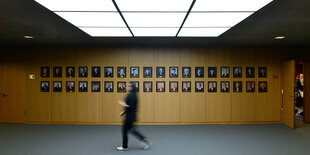 Im Bundesarbeitsgericht läuft eine Mitarbeiterin in Erfurt an den Portraits früherer Bundesrichter vorbei