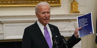 US-Präsident Joe Biden spricht mit Unterlagen zur Strategie der Bekäpfung der Coronapandemie in der Hand