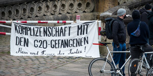 Ein Protest-Transparent hängt vor dem Hamburger Gericht, zwei Personen stehen daneben