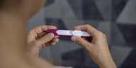 Eine Frau überprüft einen Schwangerschaftstest