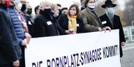 Mit einem Transparent "Die Bornplatz-Synagoge kommt"S stehen Unterstützer:innen vor dem Reichstagsgebäude in Belin