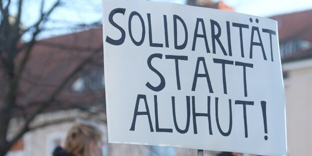Auf einem Schild steht „Solidarität statt Aluhut“