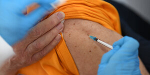 Ein alter Mensch wird von einer medizinischen Fachkraft mit dem Pfizer-BioNTech-COVID-19-Impfstoff geimpft.