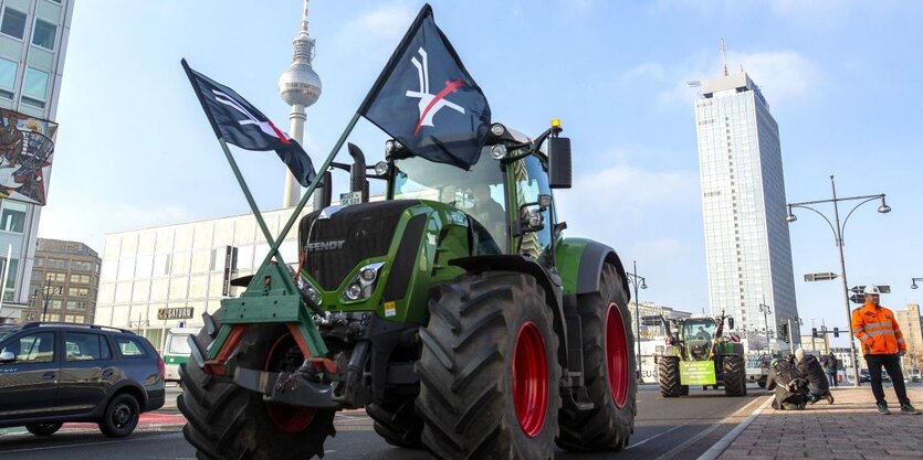 Ein Traktor mit zwei Fahnen im Hintergrund ist der Fernsehturm zu sehen