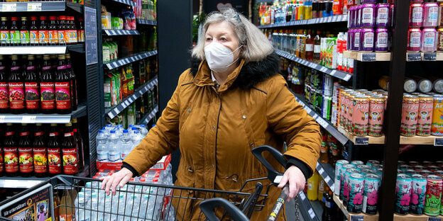 Eine Frau trägt eine FFP2 Maske in einem Supermarkt