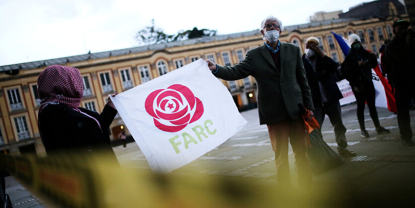 Zwei Demonstranten halten eine FARC-Fahne