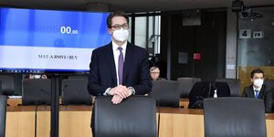 Andreas Scheuer steht mit Maske hinter seinem Stuhl im Sitzungssaal