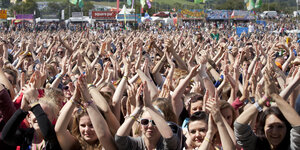 Menschen sind bei einem Konzert und halten ihre Hände in die Luft