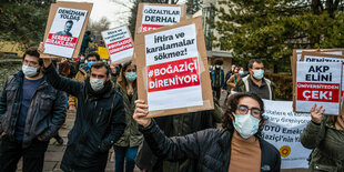 Protestierende halten Schilder in die Höhe