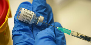 Eine Dosis Impfstoff wird aus einem Flässchchen mit einer Pipette entnommen