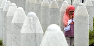 Ein Mädchen trauert auf einem Friedhof