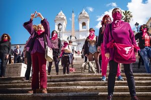 Frauen in roter Kleidung stehen protestierend auf einer Treppe