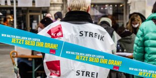 Ein Verdi-Banner vor streikenden Menschen