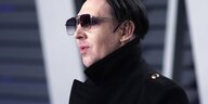 Musiker Marilyn Manson mit dunkler Sonnenbrille und hochgeschlagenem Mantelkragen