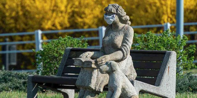 Steinskulptur von Frau mit Hund