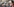 Mann mit Maske hält einen brennenden Geldschein in der Hand