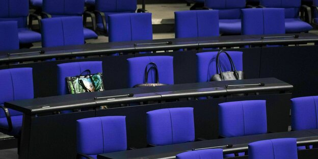 Drei Handtaschen liegen auf Plaetzen der FDP-Fraktion im Bundestag