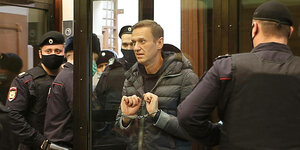 Alexei Nawalny mit Handschallen im Gerichtssaal - neben ihm Polizisten