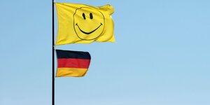 Smiley-Flagge und Deutschlandflagge an einem Fahnenmast