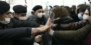 DemonstrantInnen stemmen sich gegen die Schutzschilde von Polizisten