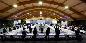 Ein großer Saal - rechteckig angeordnete Tische mit Vertretern der libyschen Kriegsparteien